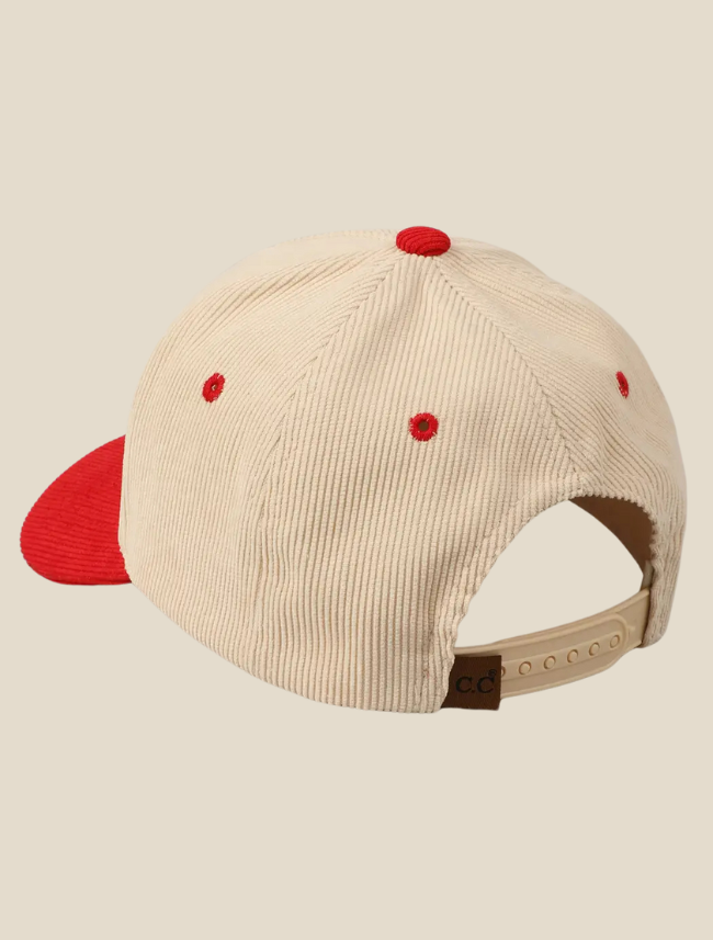 Side view of 5-panel corduroy cap in brown and cream tones on wooden surface