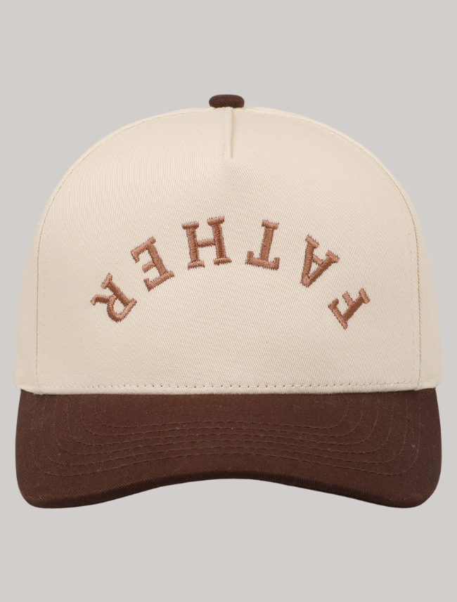 Trucker hat with ‘Father’ embroidered upside down in bold brown thread on a cream front panel with tan bill.