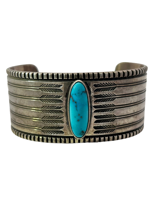 Front view of Harrison Jim Sterling Silver Turquoise Cuff with arrow detailing and large, oval turquoise cabochon in the middle
