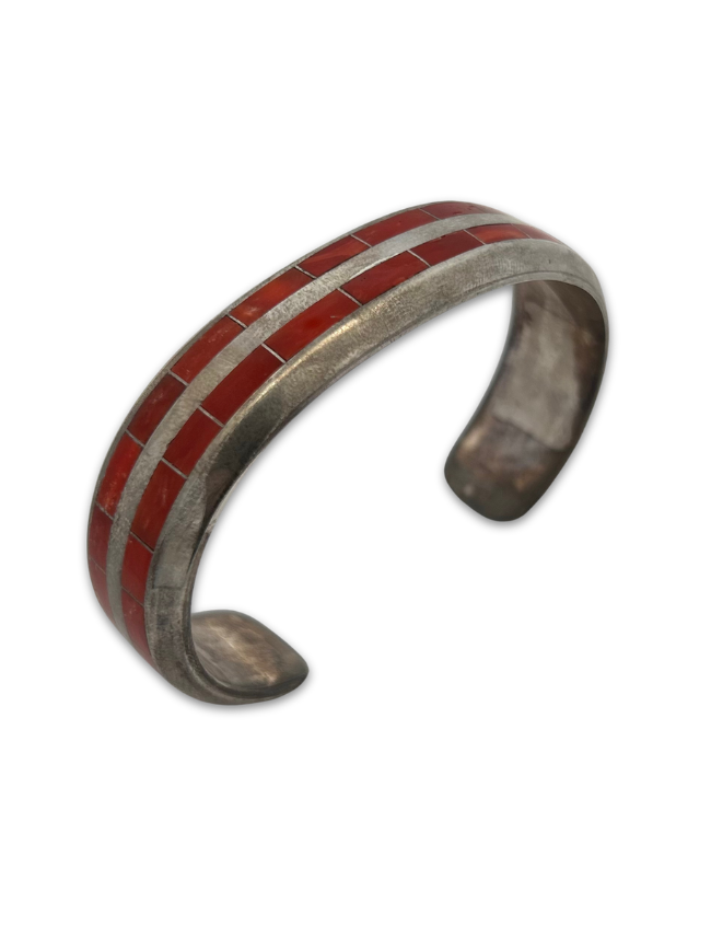 Three quarter view of Johnny Coonsis sterling silver coral inlay cuff bracelet