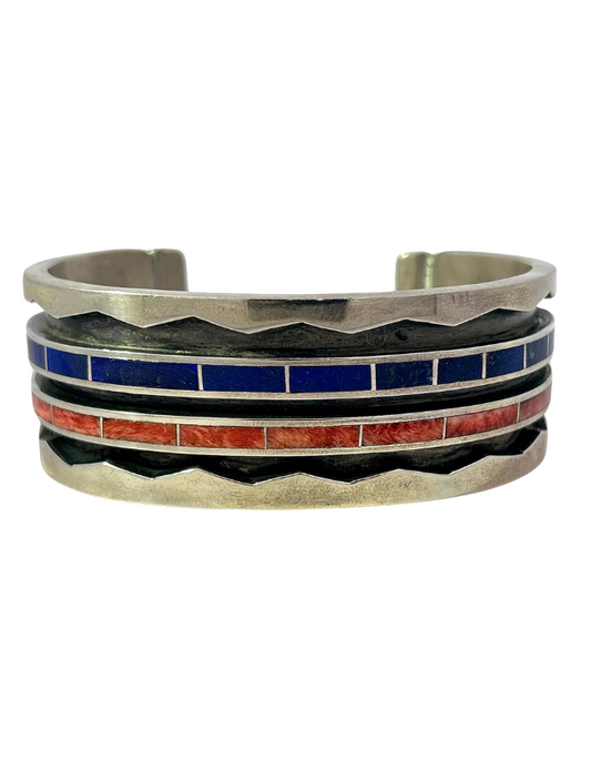 Front view of Sterling Silver Inlay Cuff by artist Lawrence Loretto with blue and orange stone inlay