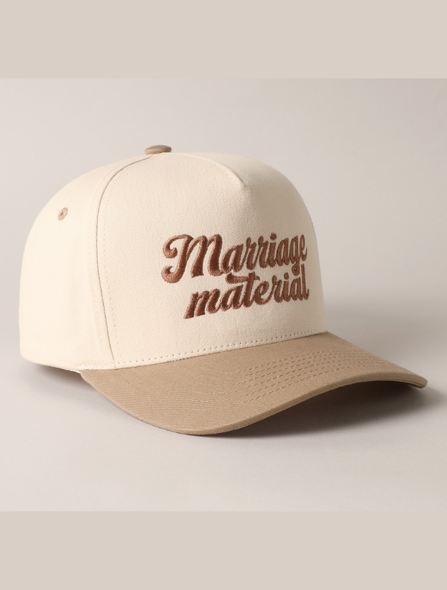 Adjustable snapback closure on a classic cream and tan trucker hat with a breathable mesh back.