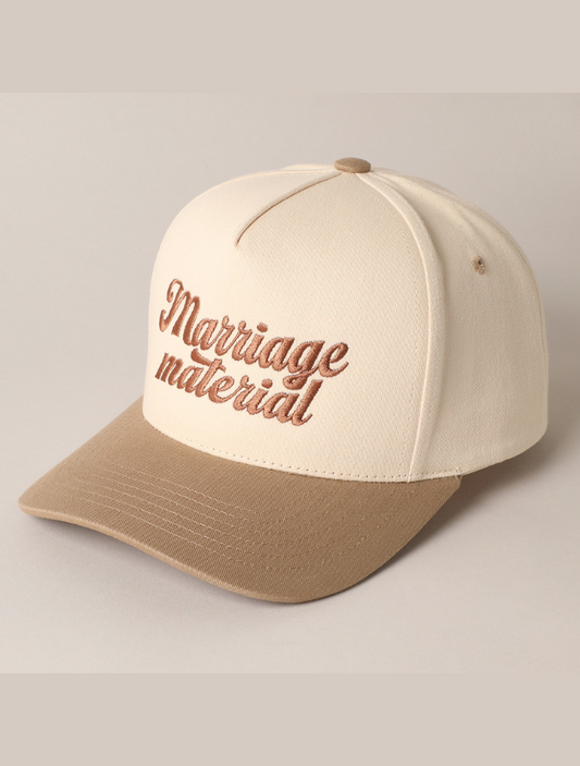 Cream and tan trucker hat with “Marriage Material” embroidered in bold, retro script on the front panel.