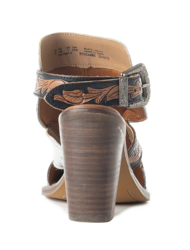 Close-up of the heel on a brown leather bootie with decorative strap and buckle on a white background
