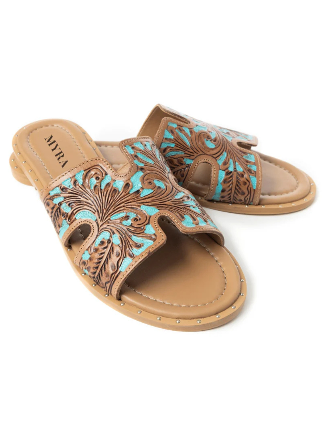 Pair of tan sandals with turquoise floral patterns on a white background