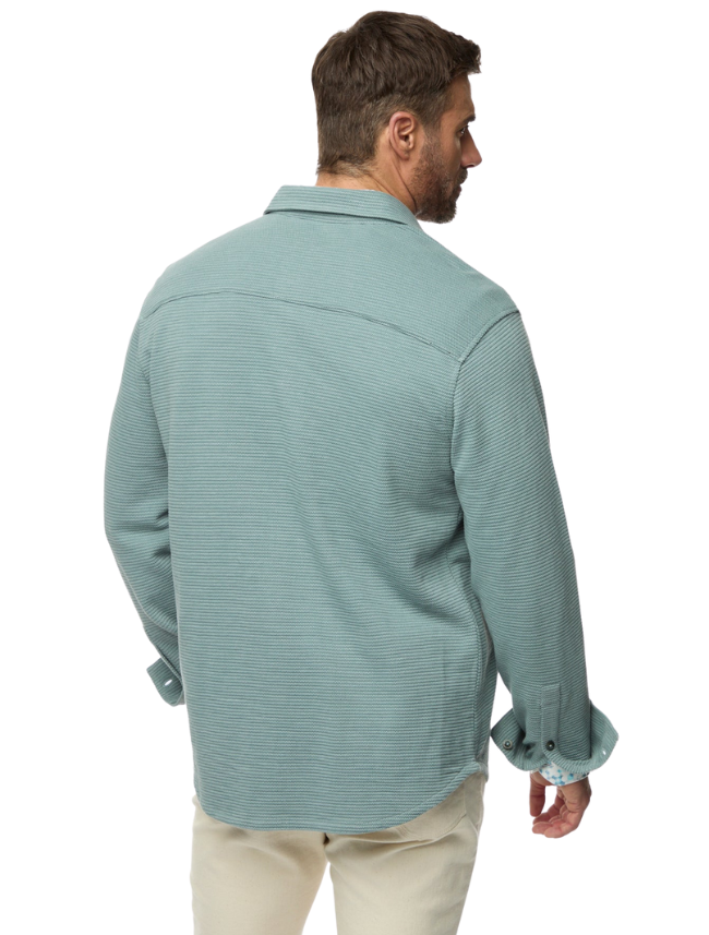 Man wearing a light blue textured shirt on a white background