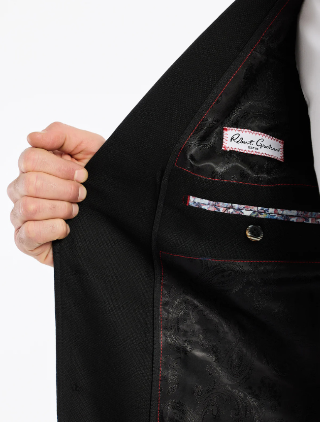 Close-up of a black suit jacket with a brand label on a white background