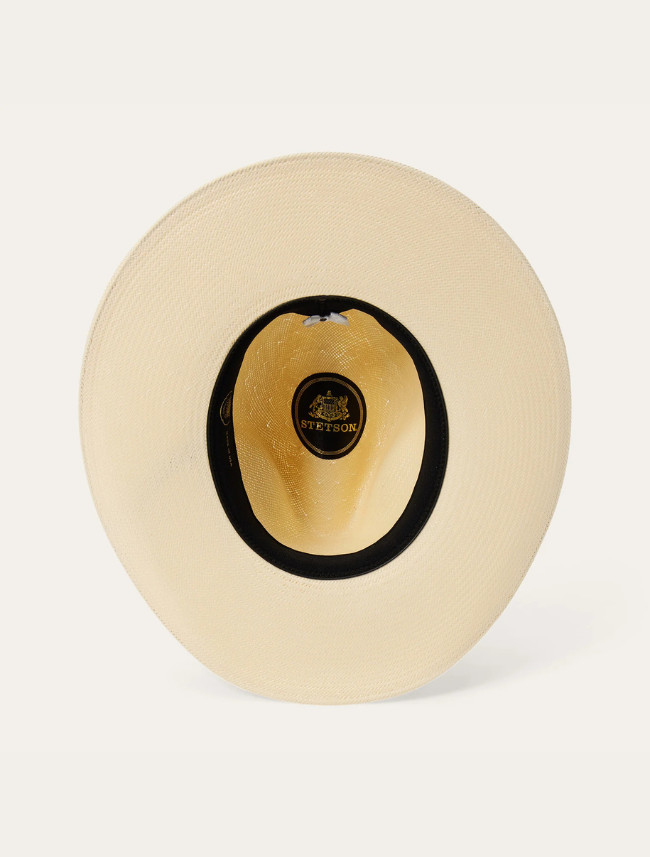 Inside view of a beige straw hat with black band on a white background