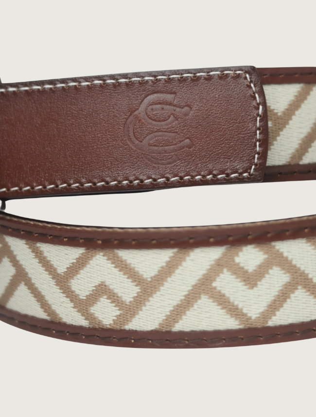 Close-up of the Trailhead belt's brown leather keeper embossed with the Cowboy Country Club horseshoe logo
