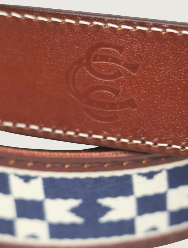 Close-up of the Del Sol belt's tan leather keeper embossed with the Cowboy Country Club horseshoe logo