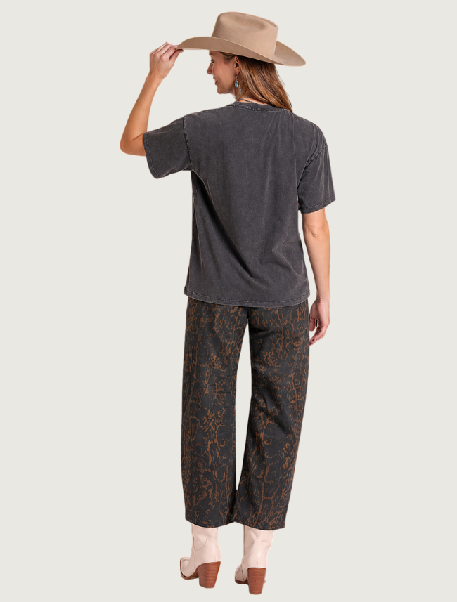 Back view of woman wearing distressed oversized RODEO graphic t-shirt, full body