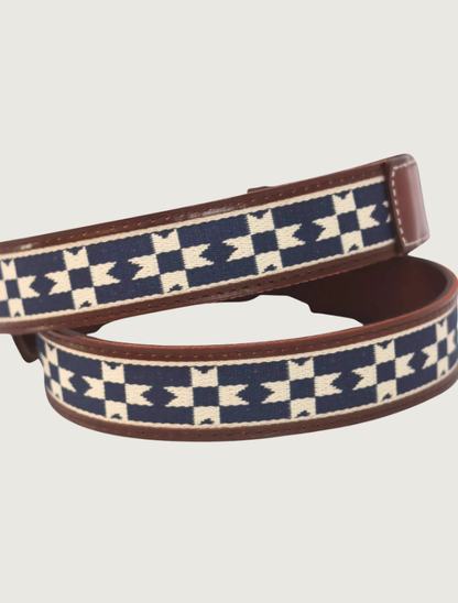 Detail of the Del Sol belt strap looped to highlight the navy-and-cream geometric weave and stitched tan leather edges