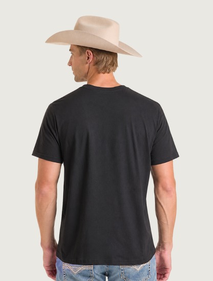 Back view of the plain black tee worn by a man in a cowboy hat