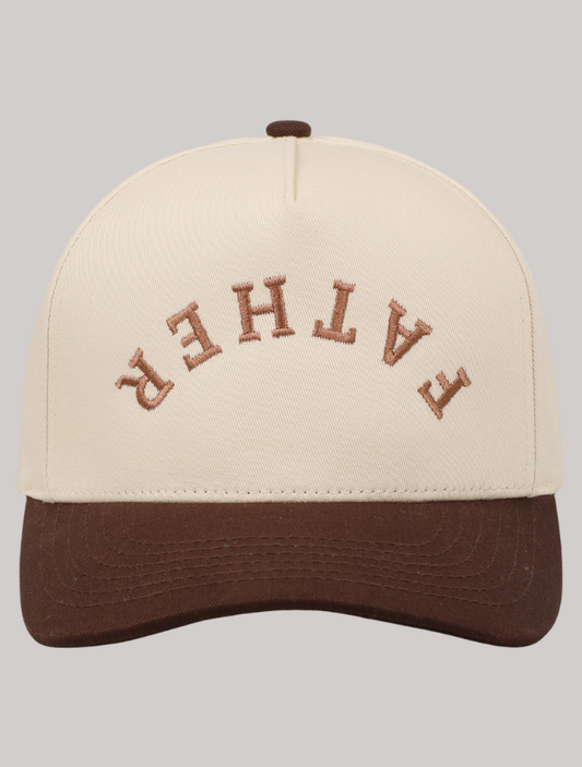 Trucker hat with ‘Father’ embroidered upside down in bold brown thread on a cream front panel with tan bill.