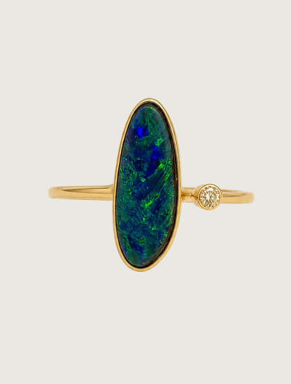 14K yellow gold bezel ring with elongated oval opal and diamond accent, front view