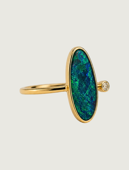 14K yellow gold bezel ring with elongated oval opal and diamond accent, side view