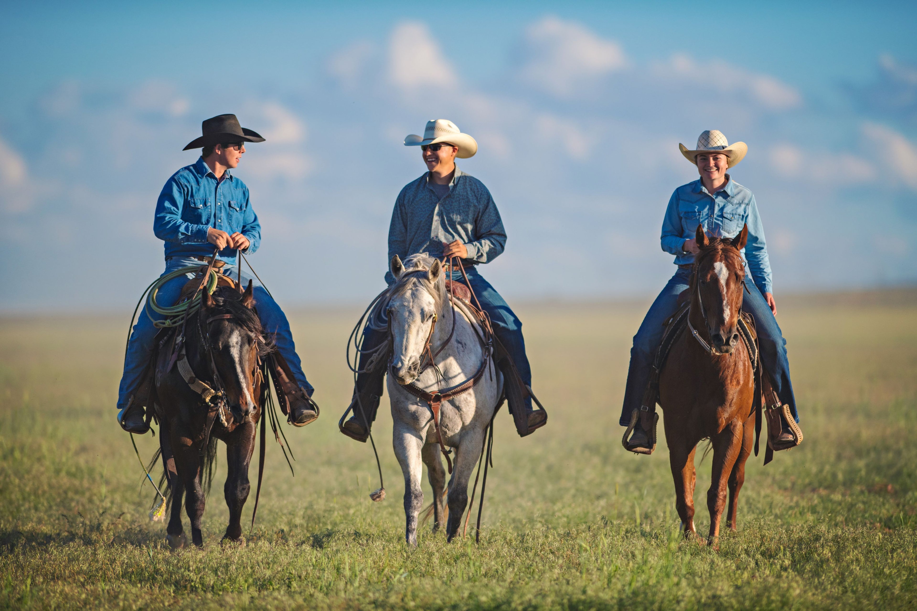 Cowboys and cowgirls riding horses in Scottsdale, wearing western apparel including cowboy hats, denim shirts, and cowboy boots, showcasing the authentic western fashion mavericks of scottsdale has in old town scottsdale.