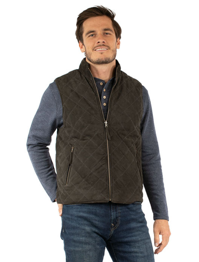 Man wearing a quilted vest over a long-sleeve shirt and jeans on a white background