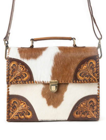 Handbag with cowhide leather design and floral tooling on a white background