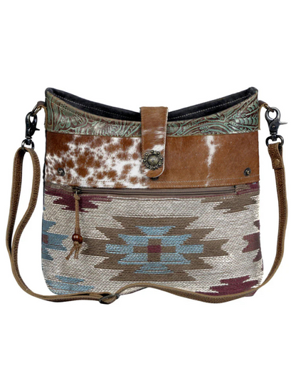 Handbag with cowhide pattern and geometric design on a white background