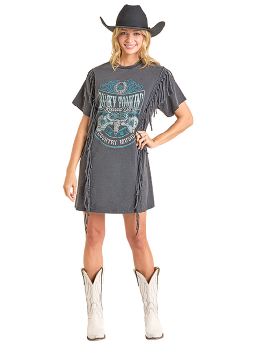 Woman wearing a gray fringe dress with a graphic design, white cowboy boots, and a black cowboy hat on a white background.