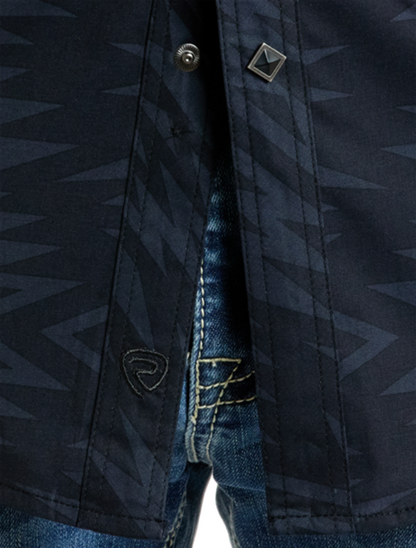 Front, close up view of the Rock & Roll Denim Men's Long Sleeve Aztec Print Western Snap Shirt with emphasis on aztec pattern, snap buttons, and black brand emblem